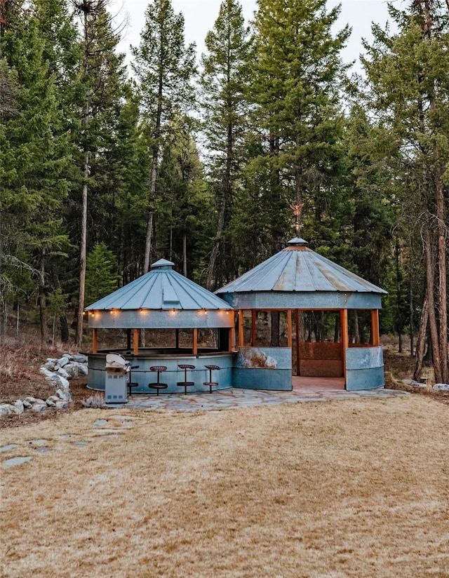 exterior space with a forest view and a gazebo