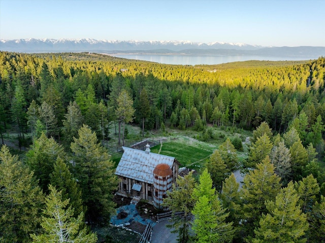 birds eye view of property with a wooded view and a water and mountain view
