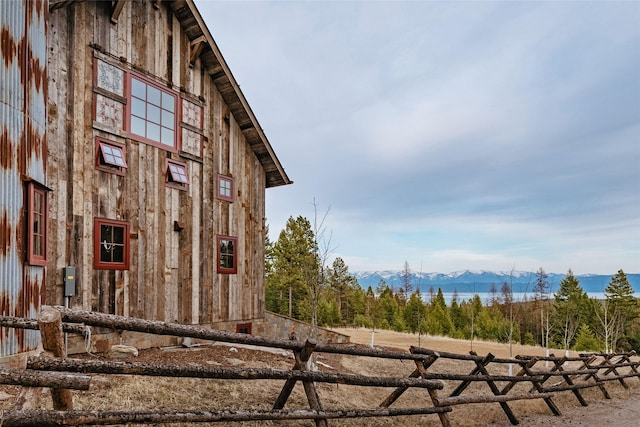 view of property exterior featuring a mountain view, crawl space, and fence