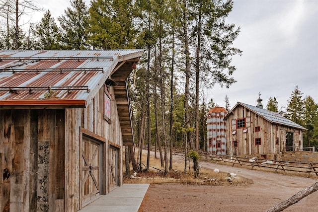 view of side of home featuring an outdoor structure and metal roof