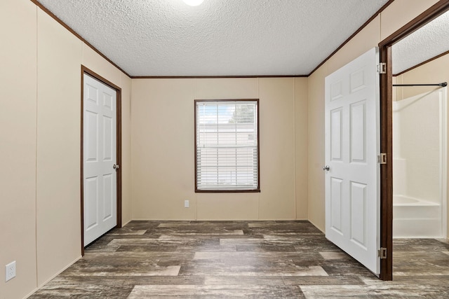 unfurnished bedroom featuring crown molding, a textured ceiling, and wood finished floors