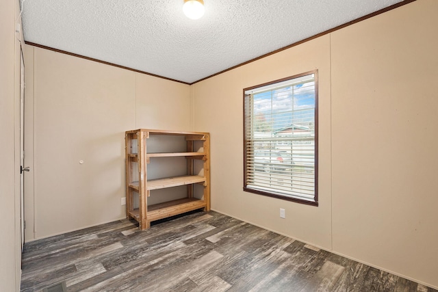 spare room featuring crown molding, a textured ceiling, and wood finished floors