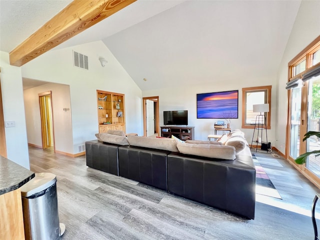 107 Crescent Lndg, Polson, MT 59860 - living area with visible vents, baseboards, wood finished floors, and high vaulted ceiling