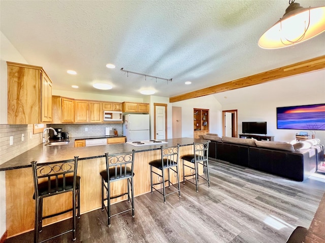 107 Crescent Lndg, Polson, MT 59860 - kitchen featuring light brown cabinetry, a sink, white appliances, vaulted ceiling with beams, and dark wood-type flooring