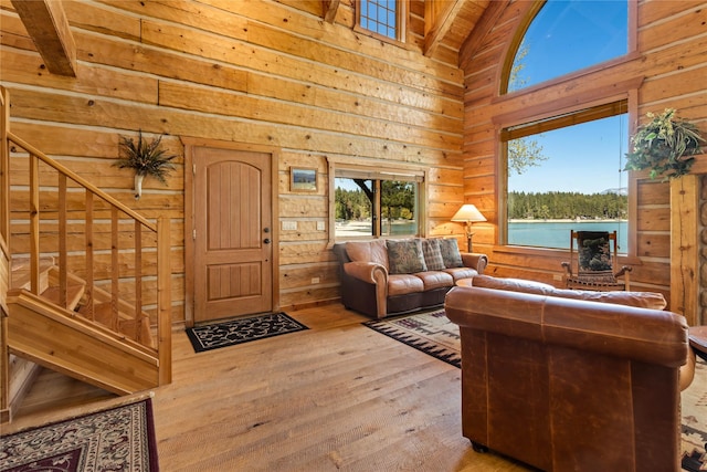 living room featuring wooden walls, high vaulted ceiling, and wood-type flooring