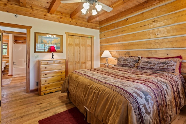 bedroom with light wood-style floors, wooden ceiling, beamed ceiling, and a closet