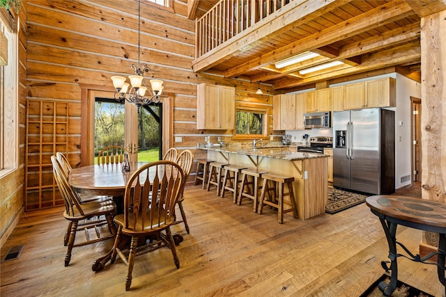 dining space featuring light wood-style floors, wood ceiling, beamed ceiling, and visible vents