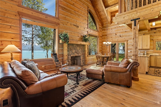 living area featuring high vaulted ceiling, wood walls, light wood-style flooring, wooden ceiling, and a healthy amount of sunlight