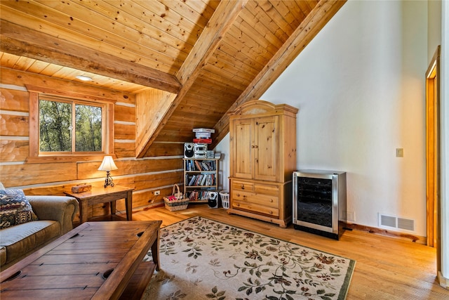interior space with lofted ceiling with beams, wooden ceiling, light wood-type flooring, wine cooler, and visible vents