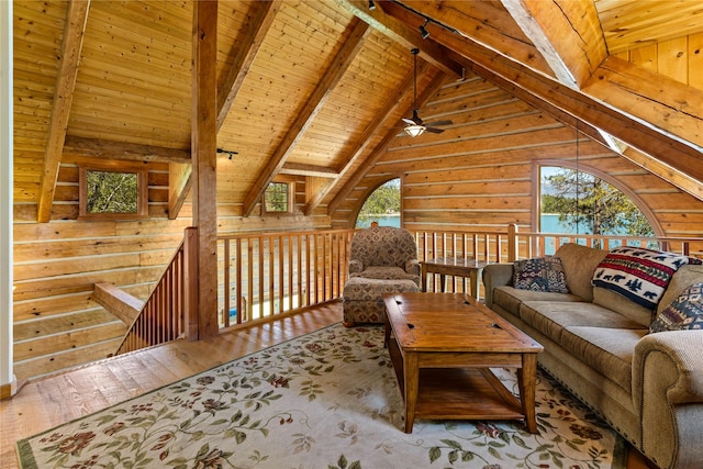 sitting room with wood ceiling, a ceiling fan, lofted ceiling with beams, wooden walls, and hardwood / wood-style floors
