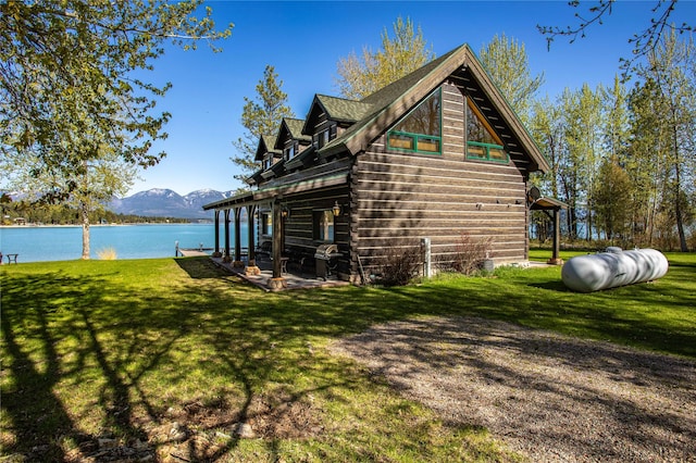 view of side of property with a water and mountain view, a yard, and a patio