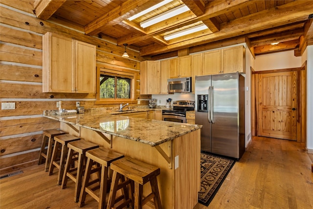 kitchen featuring appliances with stainless steel finishes, light brown cabinetry, beam ceiling, wooden ceiling, and a peninsula