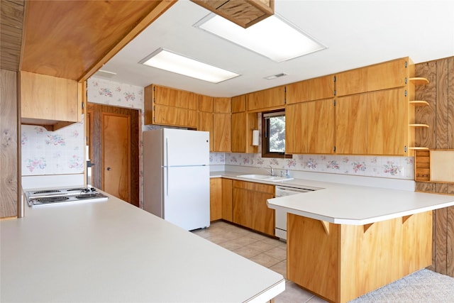 kitchen with open shelves, a sink, white appliances, a peninsula, and wallpapered walls