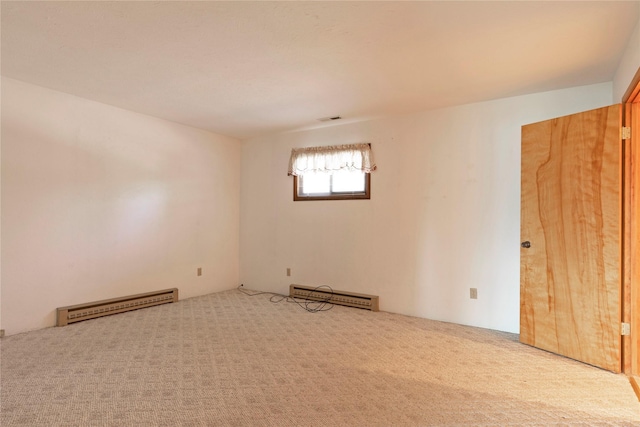 carpeted empty room featuring visible vents and baseboard heating