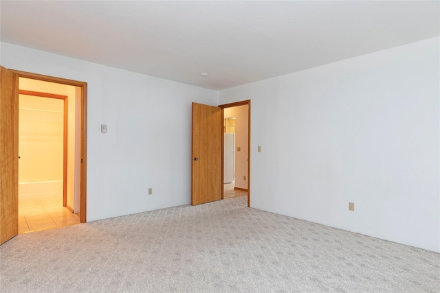 unfurnished room featuring light carpet