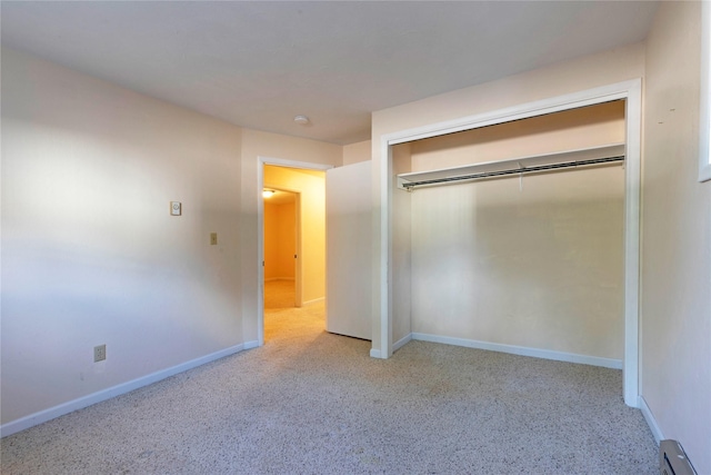 unfurnished bedroom with baseboards, carpet flooring, and a baseboard heating unit