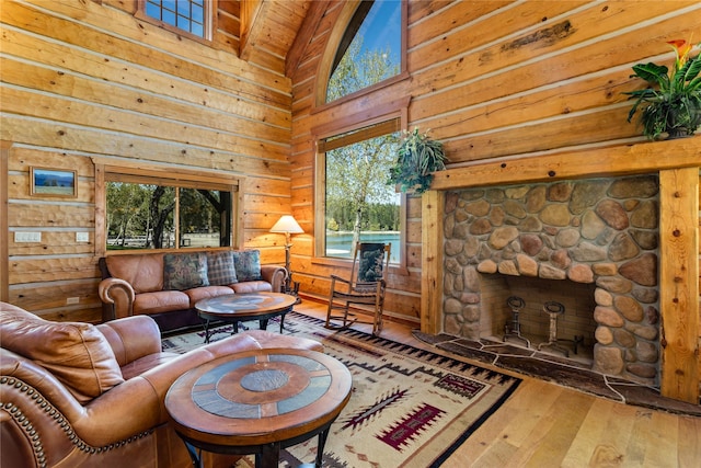 living room featuring a stone fireplace, high vaulted ceiling, wooden ceiling, wood-type flooring, and wooden walls