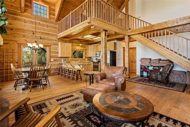 living area with plenty of natural light, light wood finished floors, and high vaulted ceiling