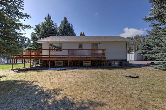 rear view of property featuring a yard, a deck, central AC unit, and roof with shingles