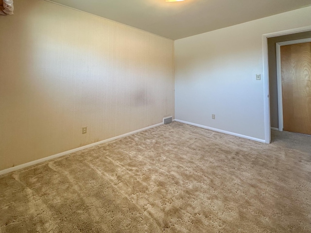 empty room featuring baseboards, carpet, and visible vents