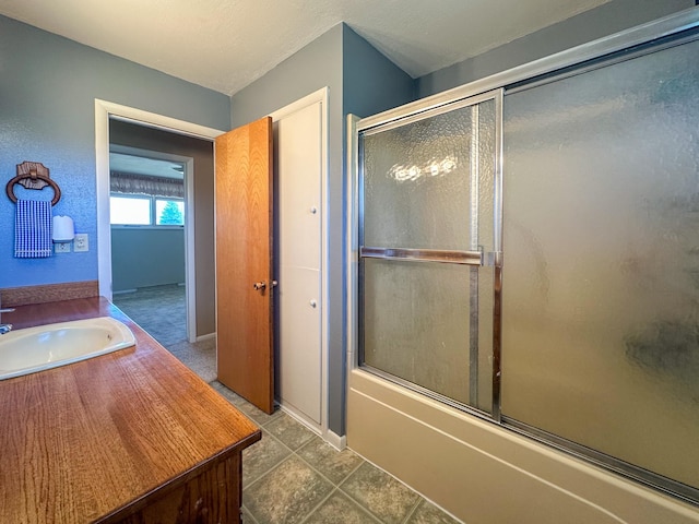 bathroom with bath / shower combo with glass door and vanity