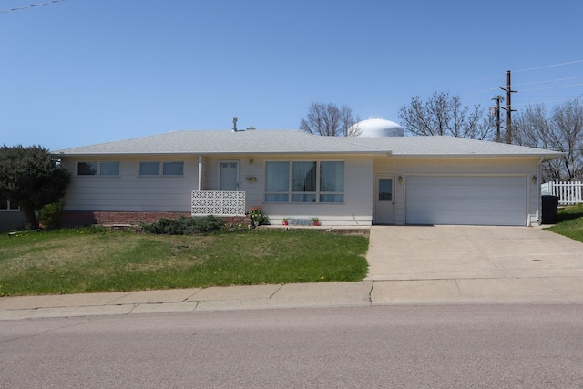 ranch-style house featuring an attached garage, driveway, and a front yard