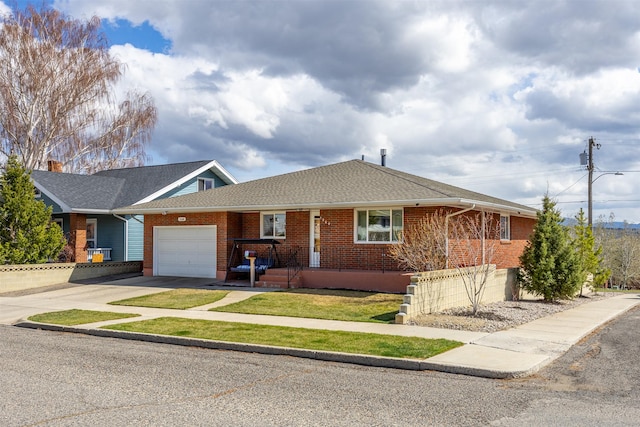 ranch-style home featuring concrete driveway, brick siding, an attached garage, and a shingled roof