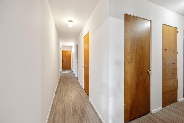 hallway with baseboards and wood finished floors