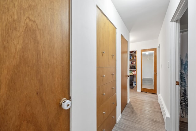 hallway with light wood-style floors and baseboards