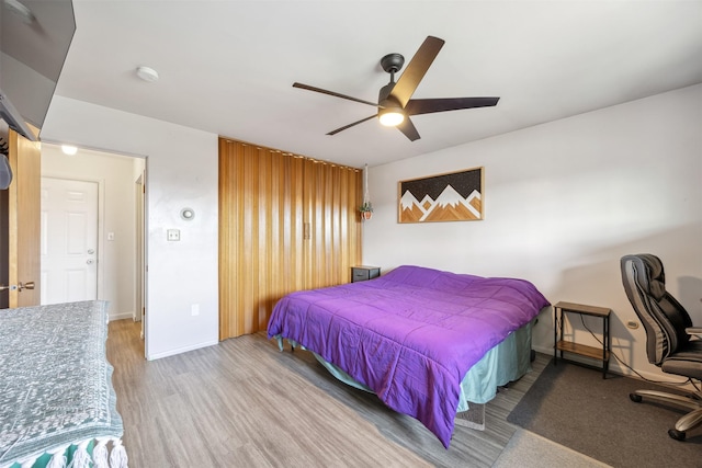 bedroom featuring baseboards, a ceiling fan, and wood finished floors