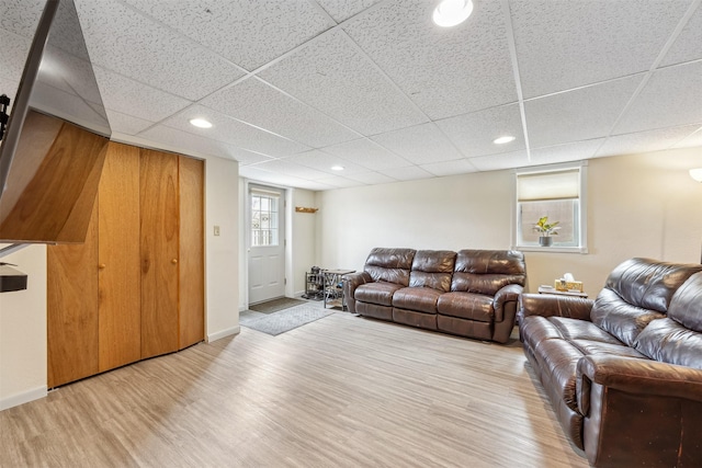 living area featuring recessed lighting, baseboards, a drop ceiling, and wood finished floors