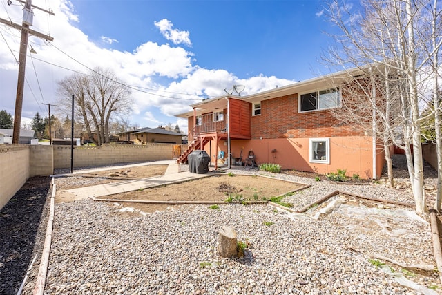 rear view of house featuring brick siding, a fenced backyard, a patio area, and stairway