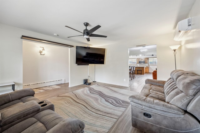 living room featuring an AC wall unit, ceiling fan, a baseboard heating unit, and wood finished floors
