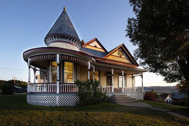victorian house featuring a lawn and covered porch