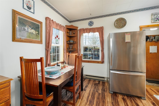 dining space with a baseboard heating unit and dark wood-style flooring