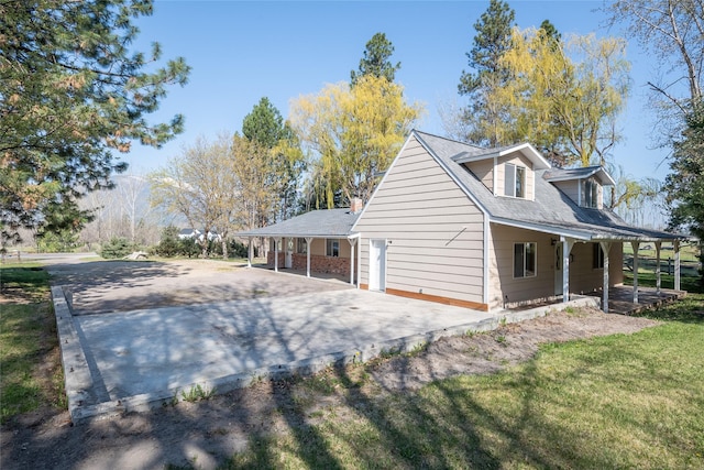 view of property exterior with a porch and driveway