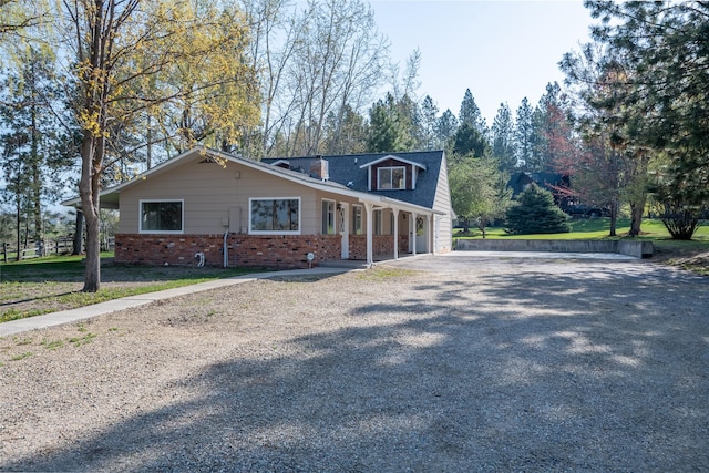 view of front of property featuring brick siding and driveway