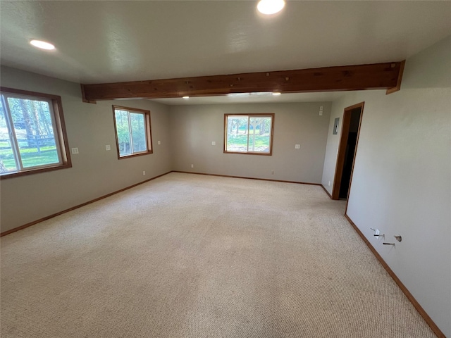 empty room with light colored carpet, recessed lighting, baseboards, and beam ceiling