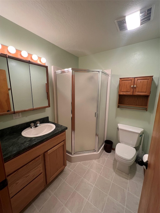 bathroom featuring vanity, visible vents, toilet, a textured ceiling, and a shower stall
