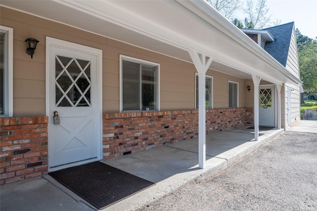 entrance to property featuring brick siding