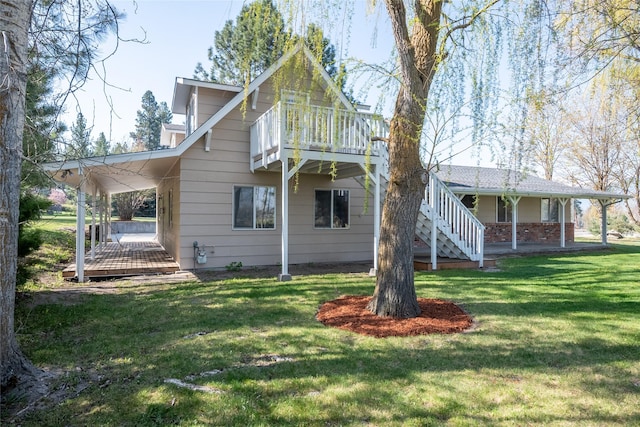 rear view of property featuring covered porch, a yard, and stairway