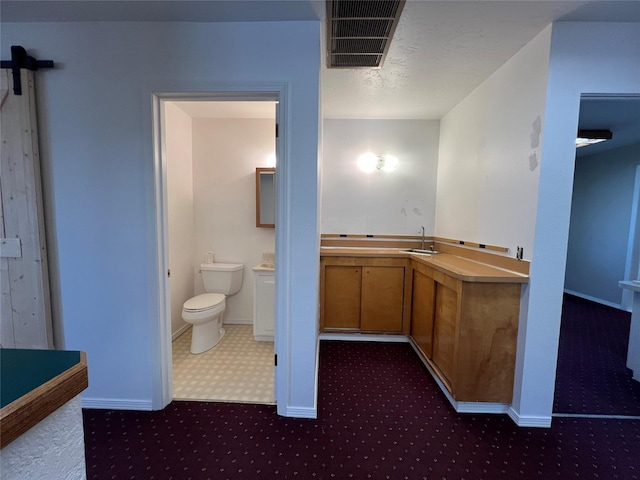 bathroom with baseboards, vanity, toilet, and visible vents