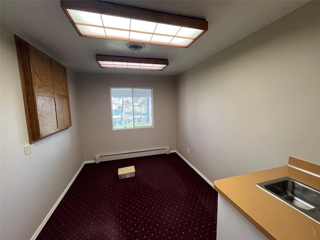 interior space featuring a sink, baseboards, a baseboard radiator, and visible vents