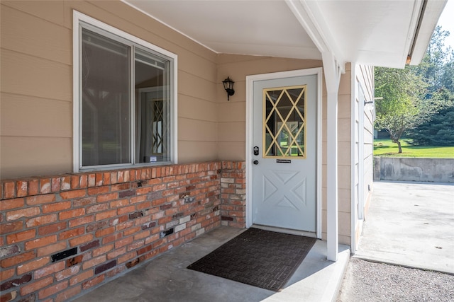 view of exterior entry with brick siding