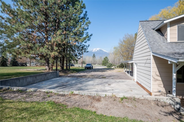 exterior space featuring a patio and a shingled roof