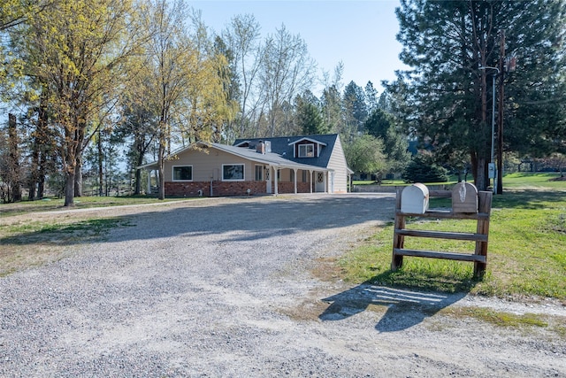 view of front facade with driveway and brick siding