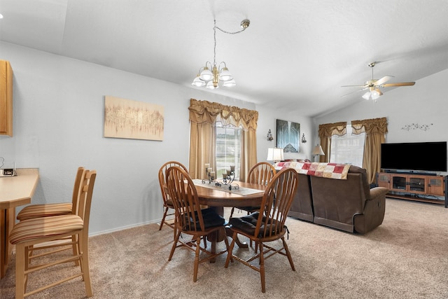 dining area with light colored carpet, baseboards, ceiling fan with notable chandelier, and lofted ceiling