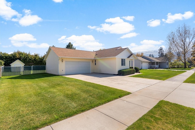view of front of home with an attached garage, fence, driveway, and a front yard