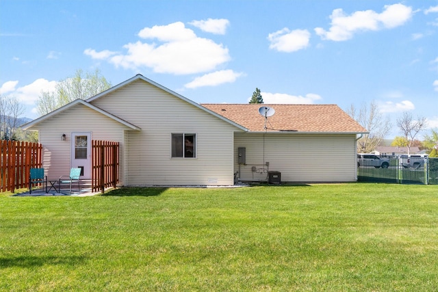 back of house with fence, a patio, and a lawn
