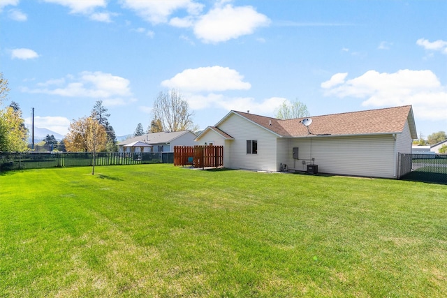 rear view of property featuring a fenced backyard, central air condition unit, and a yard